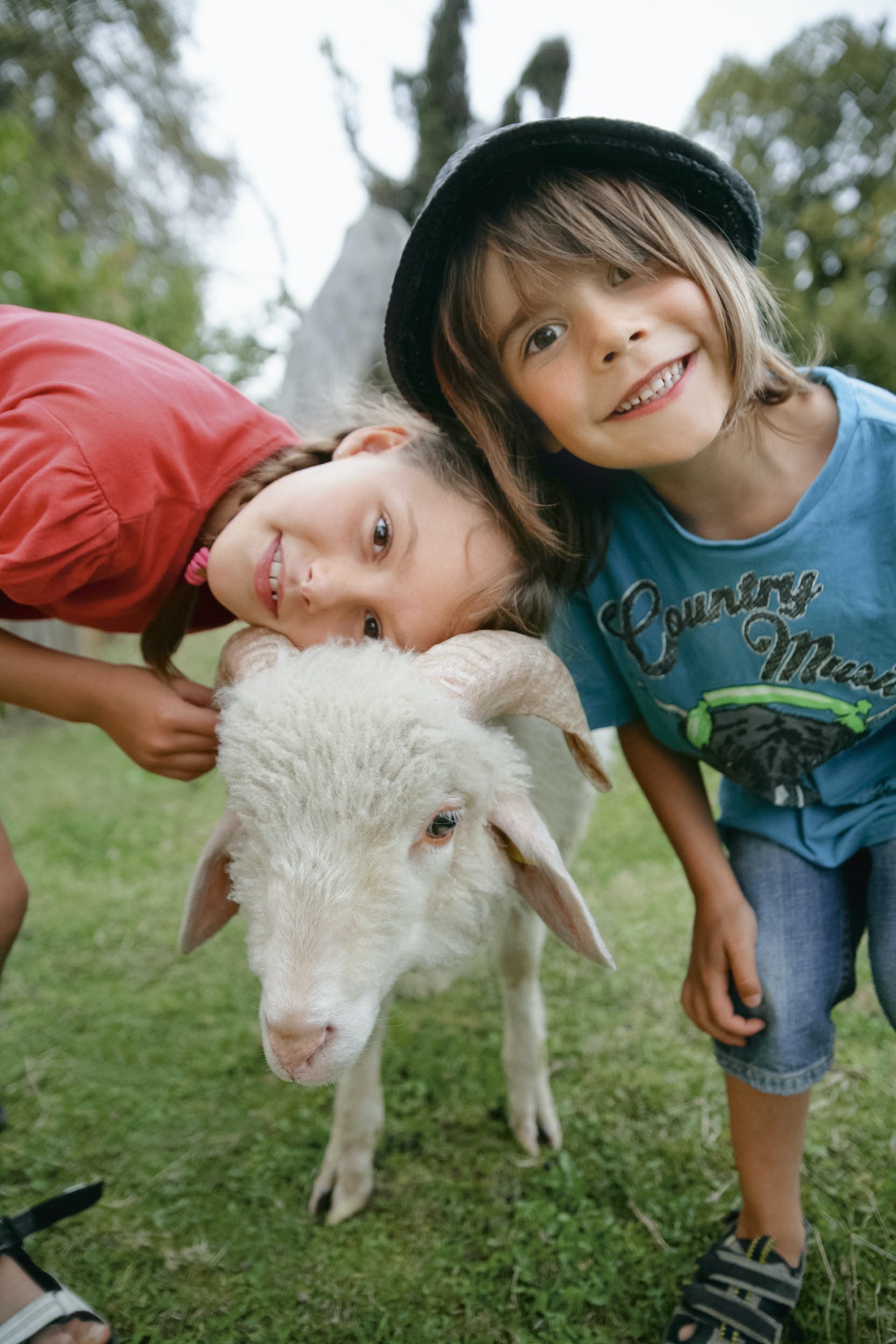 Germany, Munich, Boy and girl with sheep in children's camp